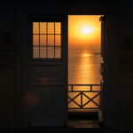 A door frame open to a sunset over the sea. Relax and trust in time.