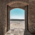 A door frame open to a terrace and the sea. Easy to trust in time here.